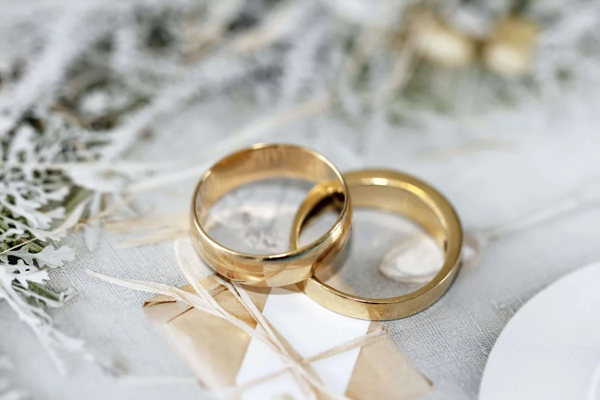 Dos alianzas de boda de oro amarillo entrelazadas