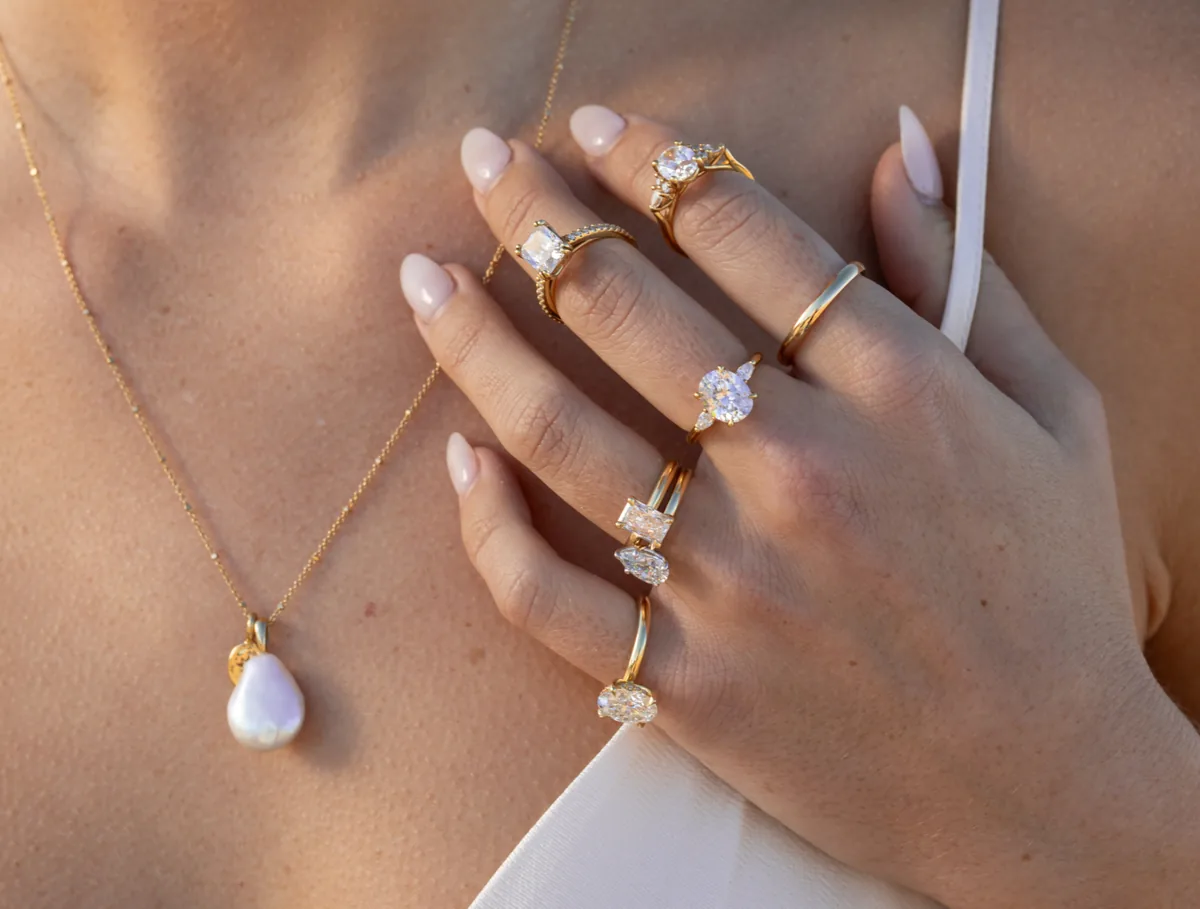 Varios anillos de compromiso de oro amarillo con diamantes de talla oval, cojín y pera