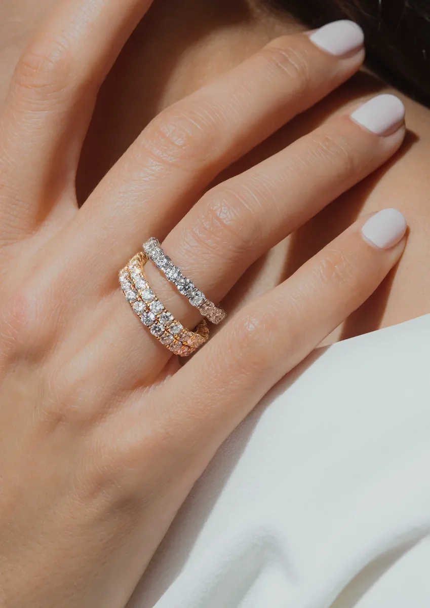 Anillos eternity de diamantes en oro amarillo y oro blanco en la mano