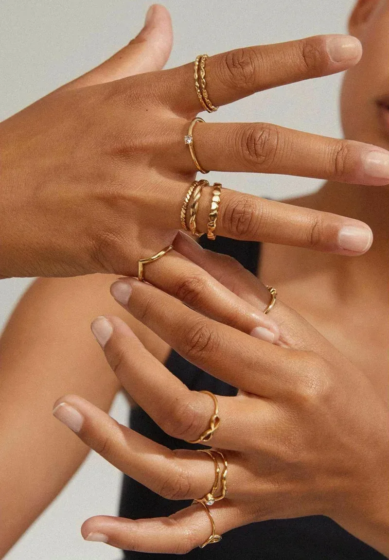 Anillos de oro finos apilados en la mano