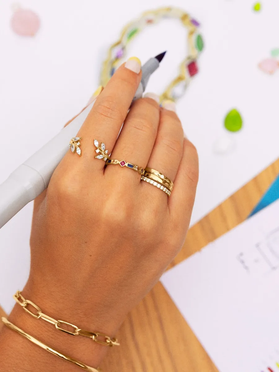 Anillo de oro abierto con hojas de circonitas y anillo con piedras de colores