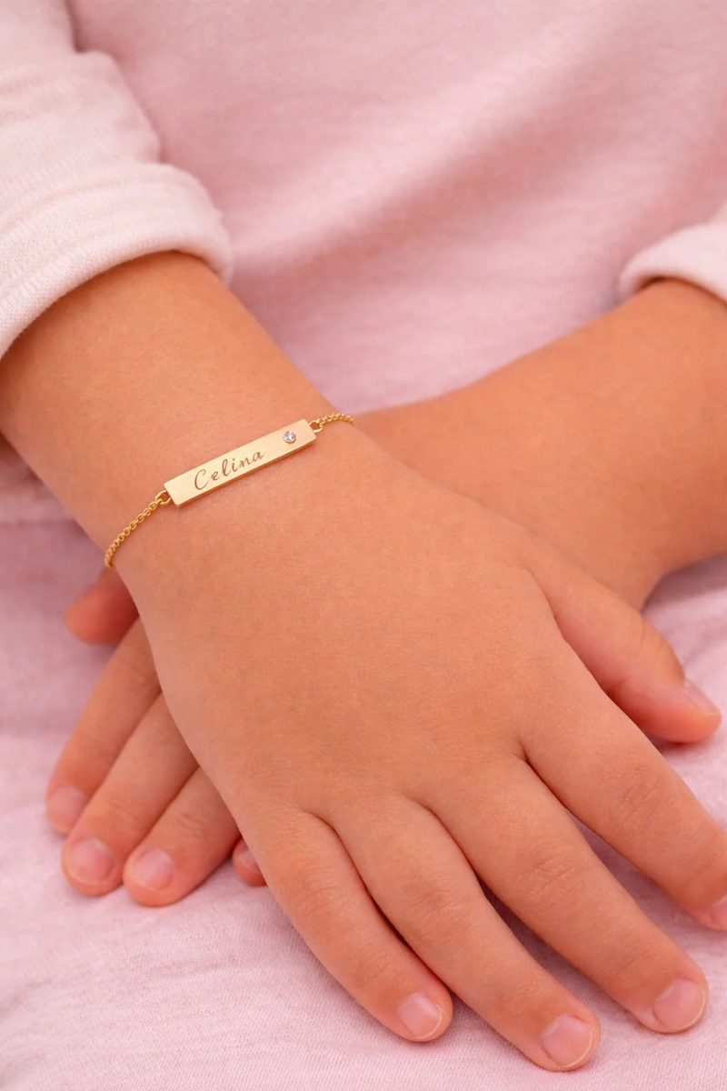 Esclava de oro con nombre grabado en la muñeca de una niña