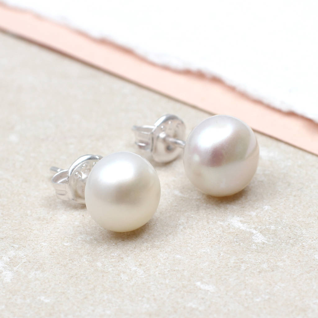 Pendientes de oro blanco con perla sobre mármol