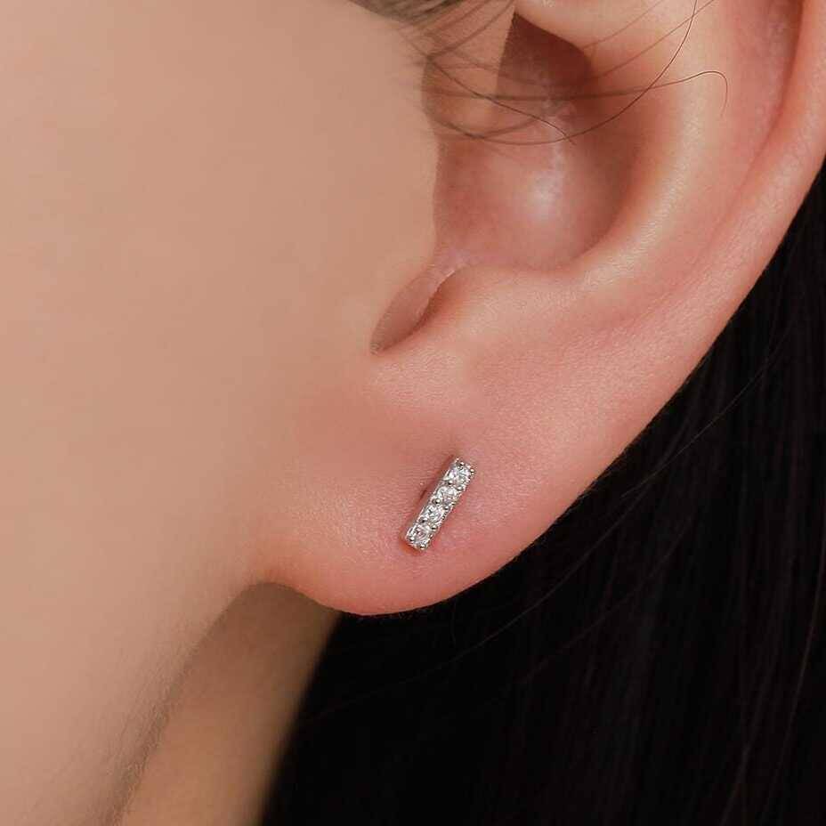 Pendiente de oro con brillantes en línea puesto en la oreja