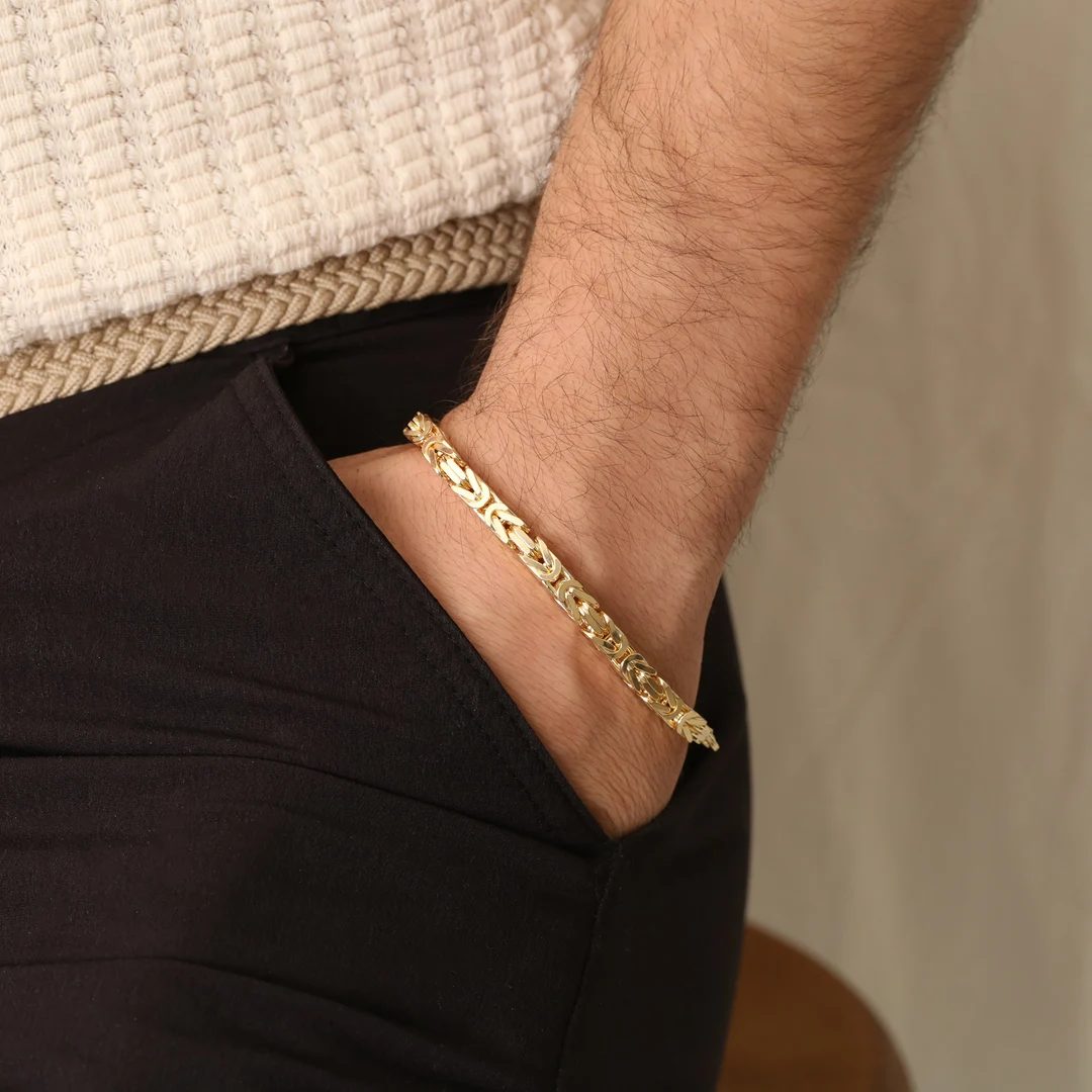Pulsera de oro de eslabón bizantino en la muñeca de un hombre