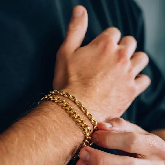 Pulsera de oro de cordón y pulsera barbada llevadas juntas por un hombre