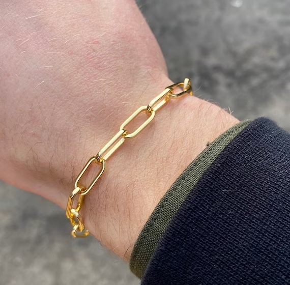 Pulsera de oro de eslabones alargados puesta en la muñeca