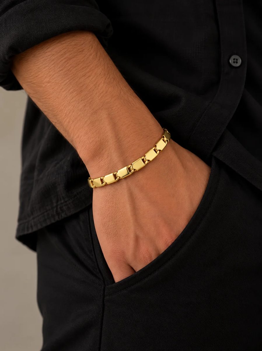 Pulsera de oro de hombre de placas lisas, con la mano en el bolsillo