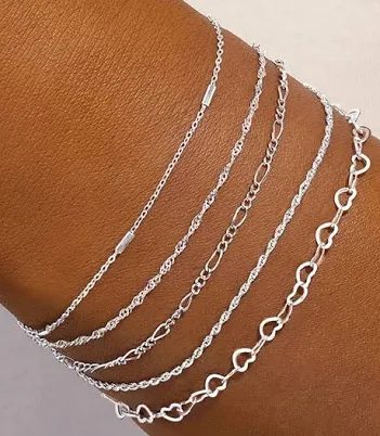 Varias pulseras finas de oro blanco de distintos eslabones