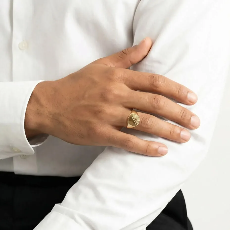 Sello de oro ovalado grabado en la mano de un hombre