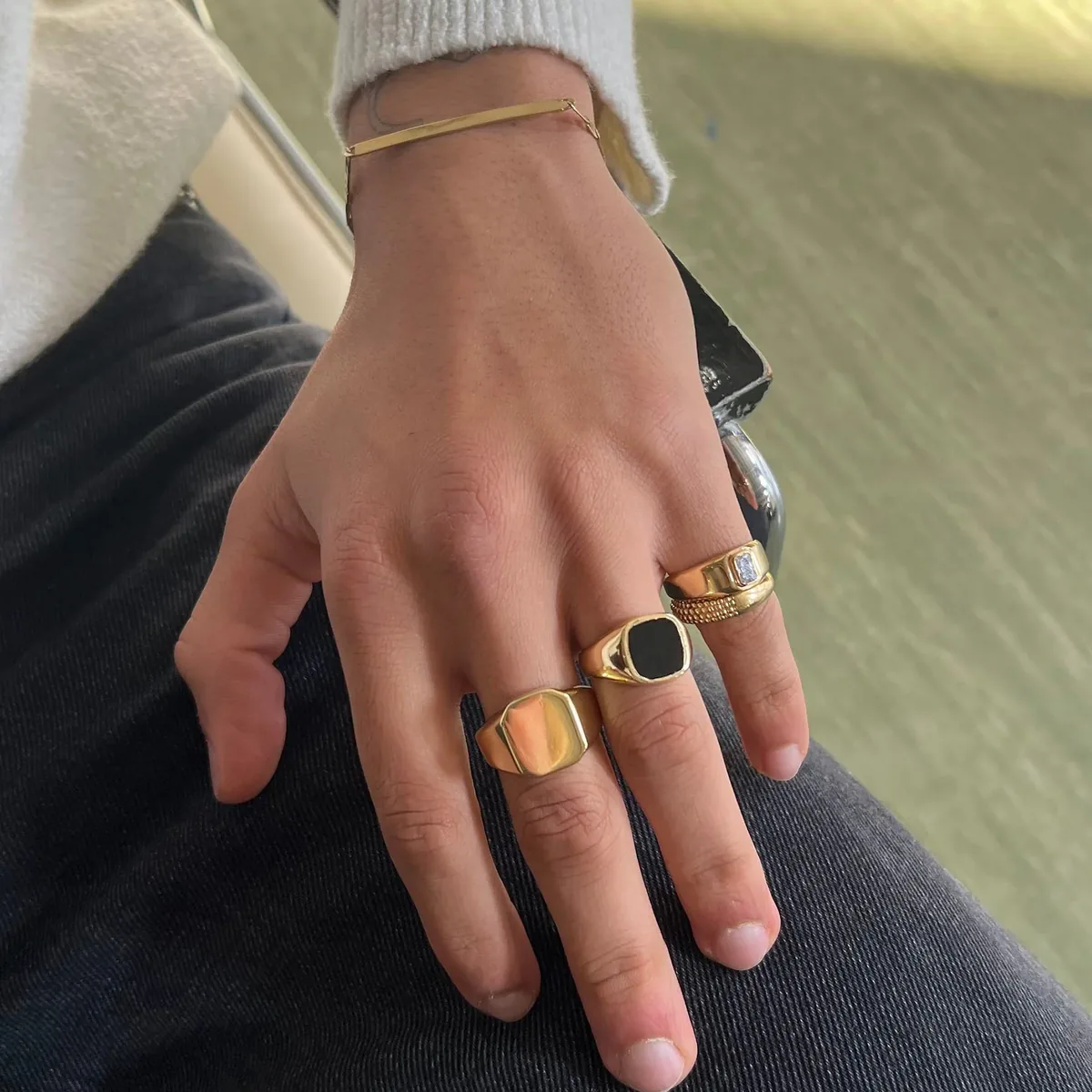 Mano de hombre con sellos de oro liso y con ónix negro